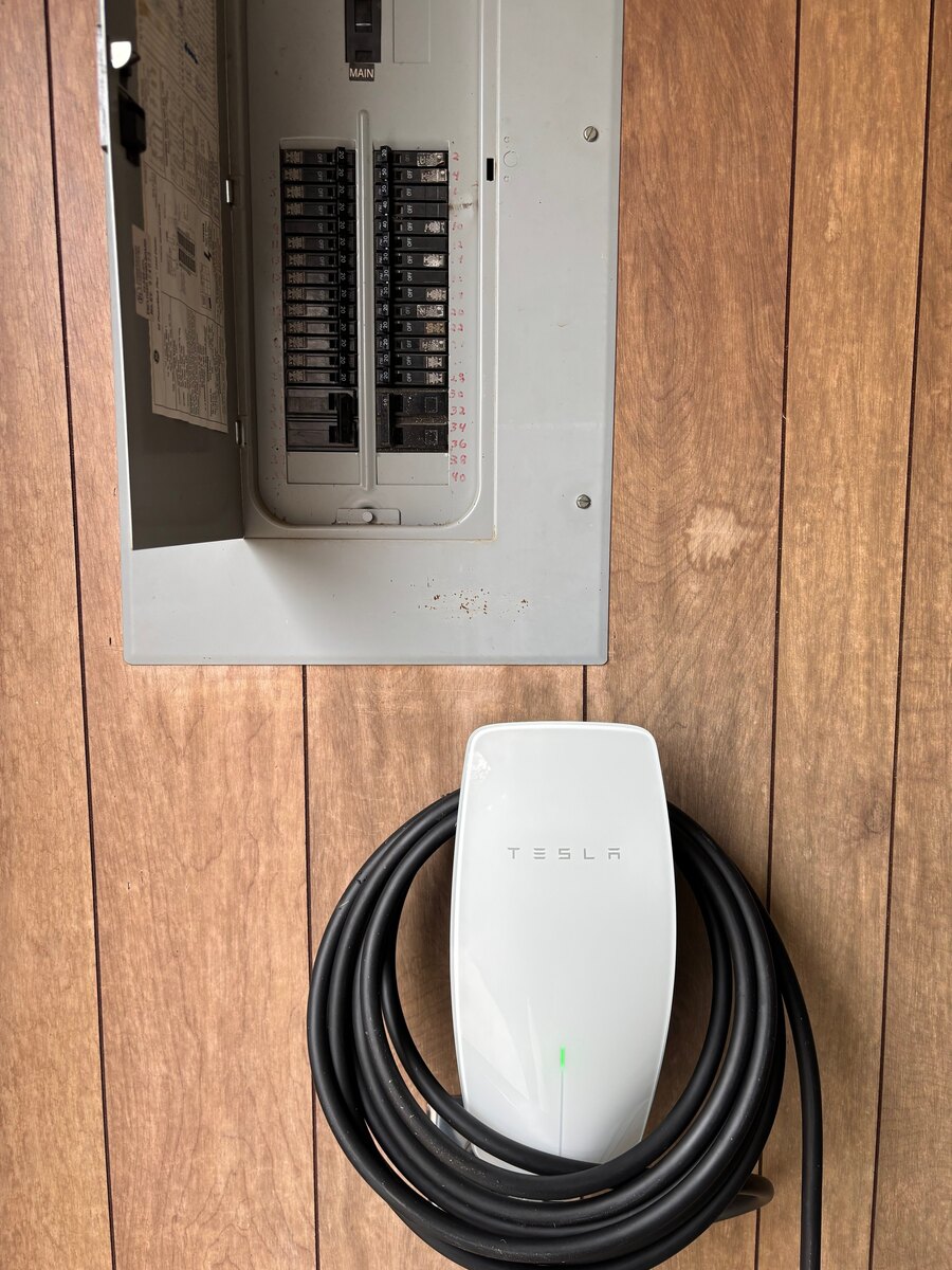 Tesla EV charger installed next to an electrical panel by LiveWire